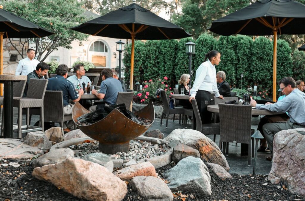 King Isosceles Sculptural Fire Pit nestled among boulders between the entry and the patio at Redstone American Grill, Minnetonka, MN