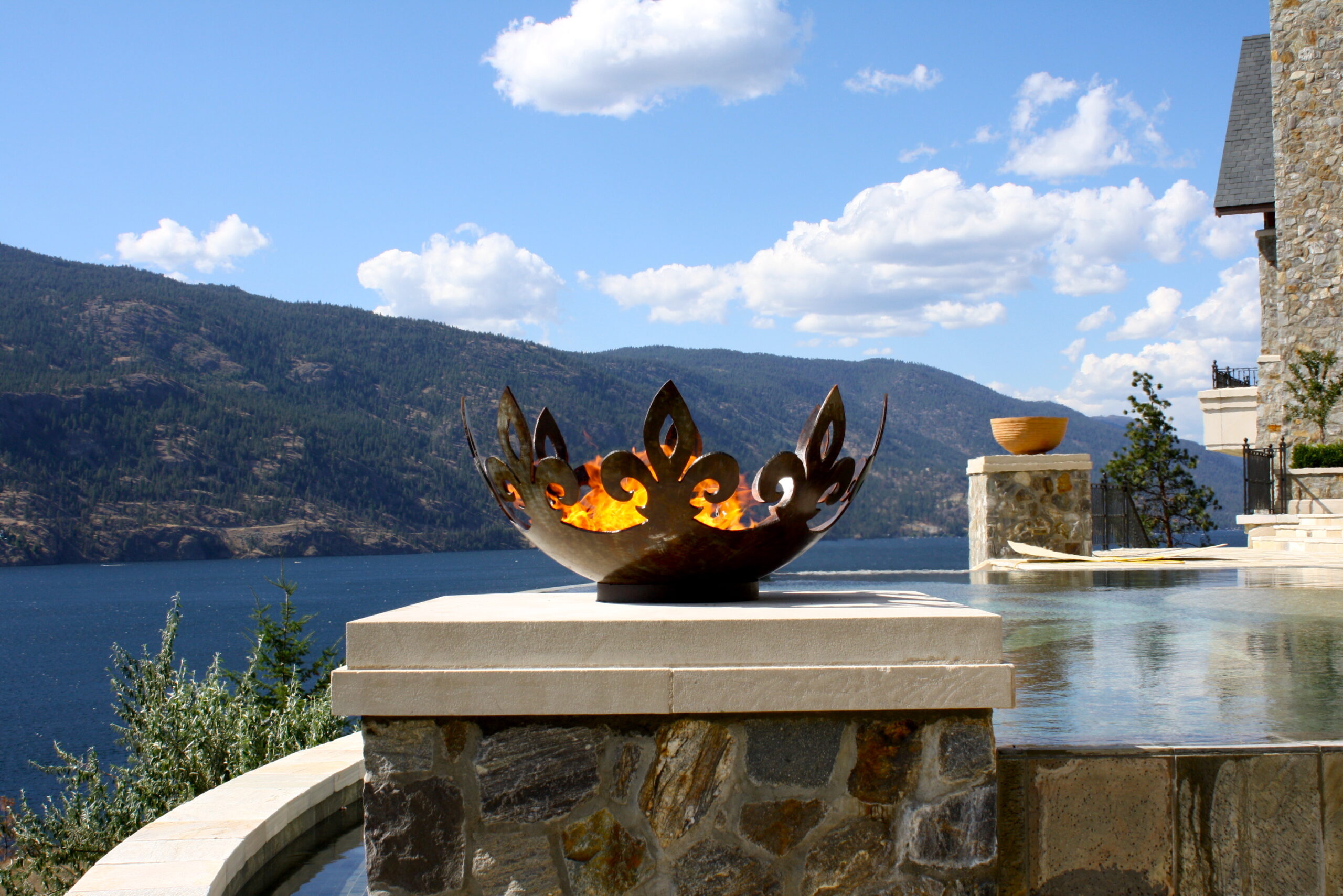 Fiery Fleur-de-lis 37 Inch Sculptural Fire Pit Flanking Infinity Pool Over Lake Okanagan