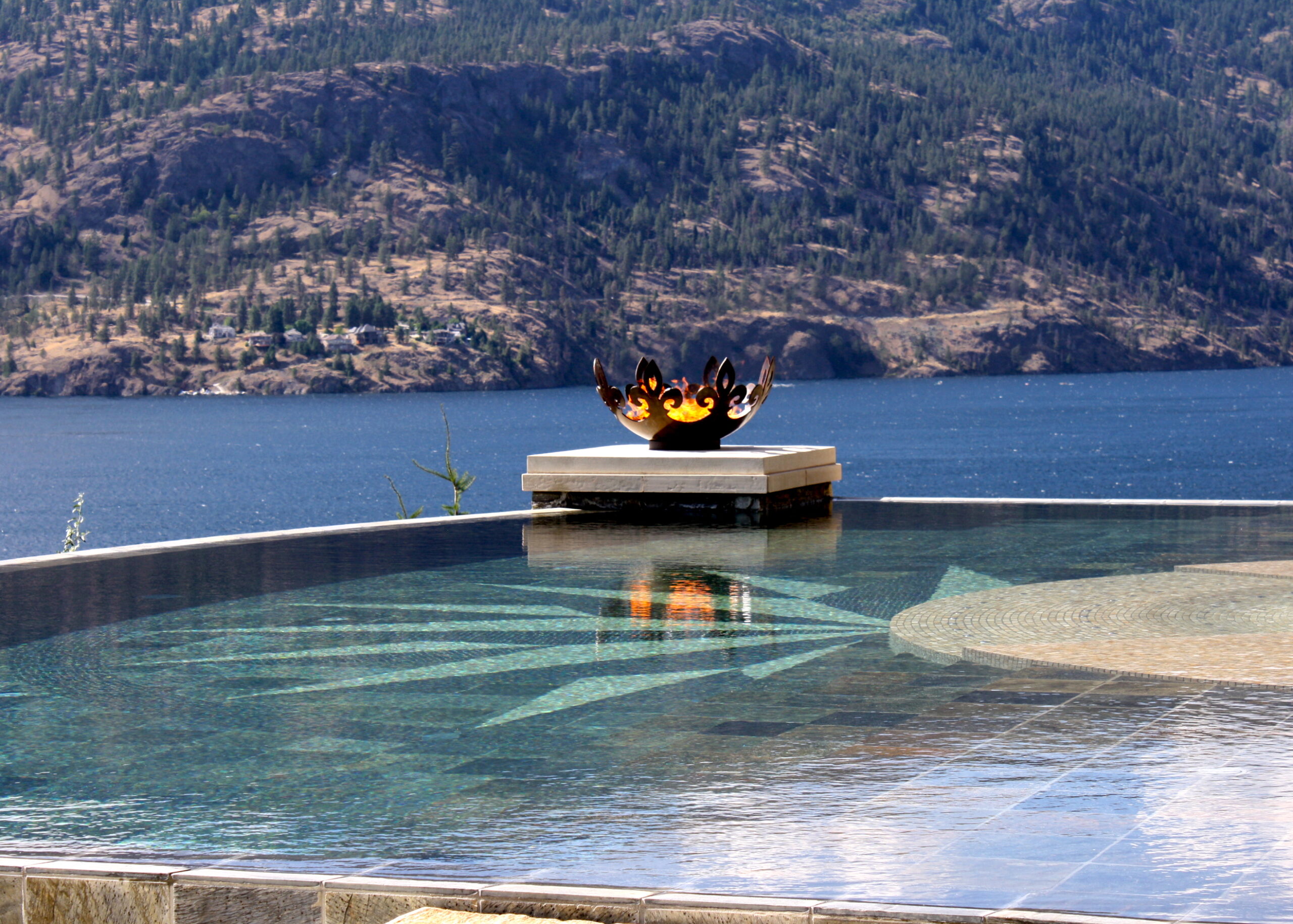 Fiery Fleur-de-lis 37 Inch Sculptural Fire Pit Flanking Infinity Pool Over Lake Okanagan